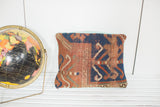 Unique antique Kazak rug pillow: worn geometric patterns in rust, navy, and faded blue linen.