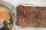 Antique Heriz rug fragment pillow: time-softened red, blue, brown geometric pattern and linen edge.