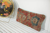 Antique Heriz rug fragment pillow, distressed red, blue, and beige patterns, mint green back.