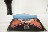 Open rug fragment clutch with light blue lining and bold Oushak pattern.