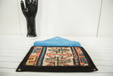 Handmade rug fragment clutch open to show its vibrant blue suede interior lining.