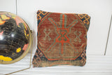 Geometric pattern in red, blue, and orange with natural wear on an antique Caucasian pillow.