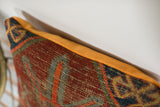 Antique Caucasian fragment pillow showcasing deeply textured tribal pattern and bright tangerine velvet.