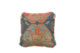 Antique Caucasian rug fragment pillow, geometric pattern in shades of blue, terracotta, and natural wear.