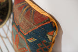 Textural side of antique Caucasian pillow, showing blue, red geometric patterns and tangerine velvet.