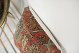 Worn hand-knotted texture and linen edge of the Heriz fragment pillow.