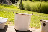 Vintage white enamel pail with rusty metal rim and handle attachments, 9x9 inches.
