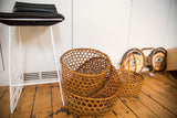 Stacked vintage hand-woven Japanese baskets, showing the dainty geometric weave in natural tan.