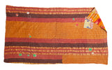 Vintage Kantha quilt's hand-stitched orange, rust, and brown striped pattern with small patches.