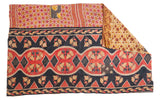 Vibrant hand-stitched Kantha quilt with coral, blue, and gold patterns, revealing a floral reverse.