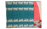 Kantha quilt's teal motorcycle pattern next to vibrant red and black patchwork.
