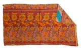 Hand-stitched vintage Indian Kantha quilt, red floral pattern, corner reveals blue reverse.