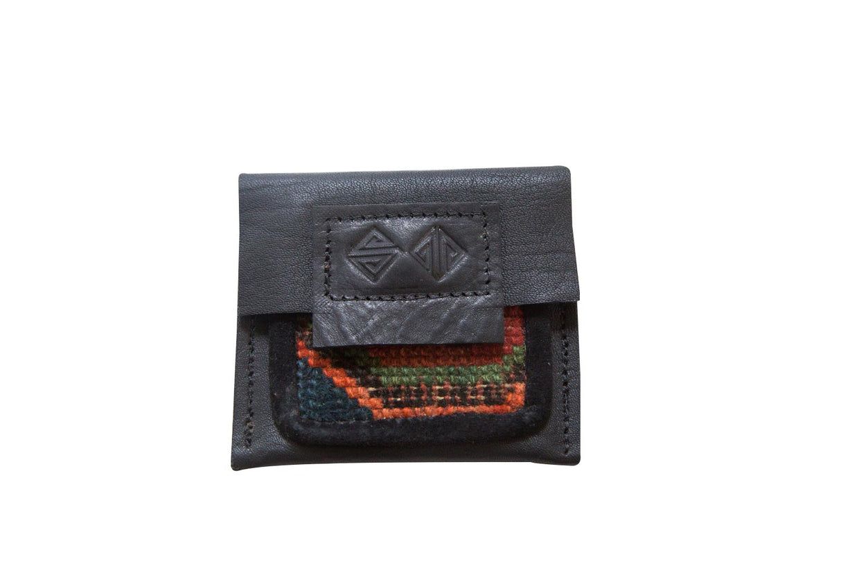 Rug Fragment Coin Purse, dark leather with vibrant geometric hand-knotted textile.