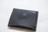 Dark vegetable suede texture and visible stitching on the coin purse.