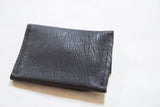 Coin purse featuring textured dark brown vegetable suede and cotton stitching.