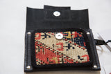 Beige, red, navy geometric hand-knotted rug fragment on open coin purse flap.