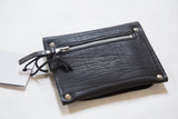 Back of the black coin purse with textured vegetable suede, metal zipper, and leather pull.