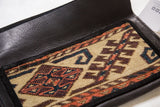Beautiful handmade rug fragment clutch with tribal geometric patterns in tan, rust, and dark blue.