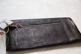 Dark pebbled vegetable suede clutch back, with metal zipper and branded tags.