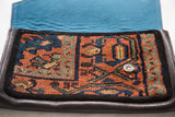 Vibrant turquoise suede lining and magnetic snap closure inside the handmade rug clutch.