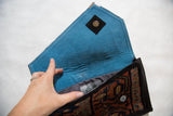 Interior of the handmade rug clutch with its blue suede lining and magnetic snap closure.