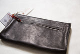 Textured black vegetable suede back of the handmade clutch with an exterior metal zipper.