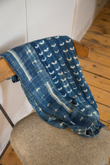 Collectible hand-woven indigo throw showing intricate white patterns and time-softened texture.