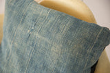 African Indigo pillow's sun-faded blue textile showing woven texture and vintage wear.