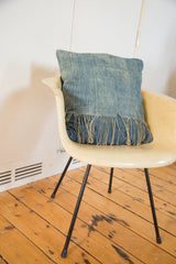 African Indigo handmade pillow with textured, sun-faded fabric and fringed lower edge.