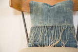 African Indigo pillow's loose fringed edge and sun-faded blue textile texture.