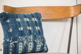 African Indigo pillow corner with faded blue vintage textile and fringed edge.