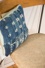 Textured African Indigo pillow detail featuring sun-faded blue motifs and a distressed edge.