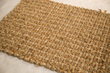 Intricate hand-braided texture with varied natural golden hemp and jute fibers.