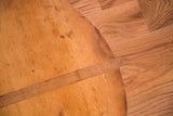 Vintage wooden pizza board detail showing rustic grain, scratches, and darkened patina.