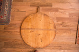 Rustic bottom edge of vintage wooden pizza board with time-softened patina.