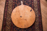 Vintage wooden pizza board displaying rustic wood grain and aged patina.