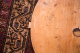 Vintage wooden pizza board edge, showing natural grain, visible marks, and dark stain.
