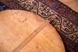 Rounded edge of vintage wooden pizza board showing rustic patina and wood strip.
