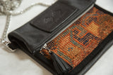 Embossed leather logo, metal zipper, and tassel on the antique Kurdish rug bag.