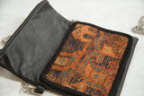 Interior view of the rug handbag with vegetable-tanned black leather and the antique woven fragment.