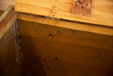Aged interior of the vintage industrial factory cart, showing dark wear marks and wood lid.