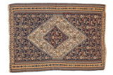 Antique Senneh Kilim rug with a concentric stepped ivory medallion on an intricate navy blue field.