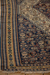 Close-up of the flatweave texture and intricate geometric borders of an antique Senneh Kilim.