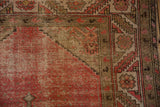 Intricate geometric border detail with blush field and worn foundation on vintage Malayer rug.