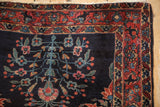Finely executed raspberry floral vines on the indigo corner of a vintage Persian Sarouk.