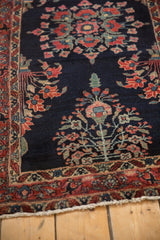 Finely executed floral bouquets and scrolling vines on the dark indigo pile of a vintage Sarouk rug.