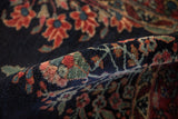 Side view of the dense, hand-knotted pile of a fine Sarouk rug with floral motifs.