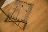 Aged wooden seat slats and dark metal frame detail of the vintage cafe chair.