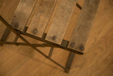 Textured aged wood seat slats and metal rivets on vintage French cafe chair.