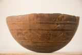 Hand-carved African bowl, close-up of geometric patterns, horizontal lines, and aged wood character.